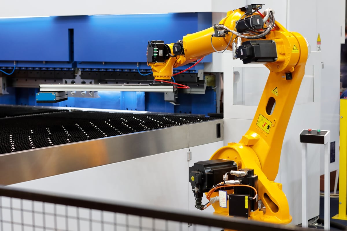 Celda robótica de doblado de lámina con robot industrial protegido por reja de seguridad